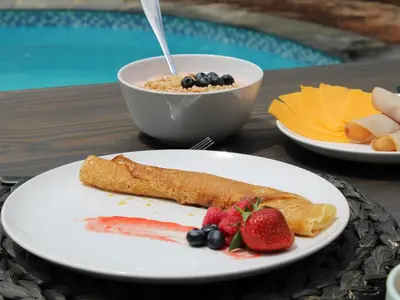 a plate of food with fruit on a table at Taaibos Bush Lodge in Hoedspruit