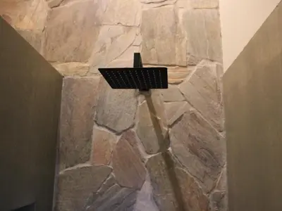 a stone wall in a bathroom with a basket on it at Taaibos Bush Lodge in Hoedspruit