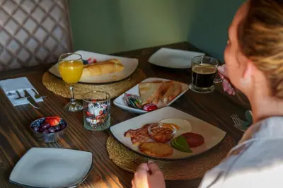 a woman sitting at a table with a plate of food at Taaibos Bush Lodge in Hoedspruit
