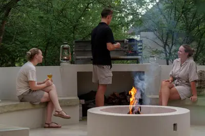 a man and two women sitting around a fire pit at Taaibos Bush Lodge in Hoedspruit