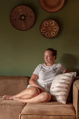 a man sitting on a couch with a pillow at Taaibos Bush Lodge in Hoedspruit