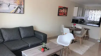 a living room with a couch and a table at Menlyn Place Staycation in Pretoria