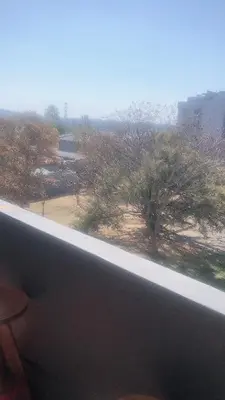 a window with a view of a field and trees at Menlyn Place Staycation in Pretoria