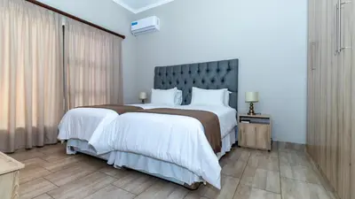 a bedroom with a large bed with white sheets at Euphoria Golfers letting House 405 Euphoria golf and life style estate in Naboomspruit