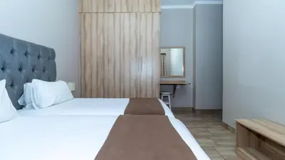 a bedroom with a large white bed and a mirror at Euphoria Golfers letting House 405 Euphoria golf and life style estate in Naboomspruit