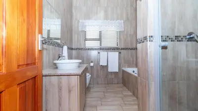 a bathroom with a sink and a toilet and a shower at Euphoria Golfers letting House 405 Euphoria golf and life style estate in Naboomspruit