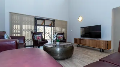 a living room with a flat screen tv and furniture at Euphoria Golfers letting House 405 Euphoria golf and life style estate in Naboomspruit