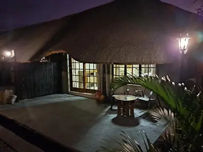 a patio at night with a table and lights at Hambana Lifestyle Lodge in Musina
