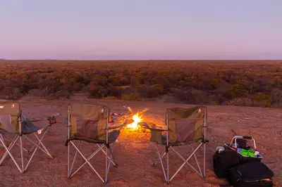 a group of three chairs sitting around a campfire at Hambana Lifestyle Lodge in Musina