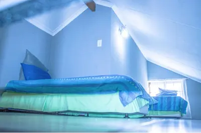 a blue bedroom with a bed with a blue comforter at 19 @ Pendleberry in Bela-Bela