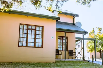 a house with two chairs in front of it at 19 @ Pendleberry in Bela-Bela