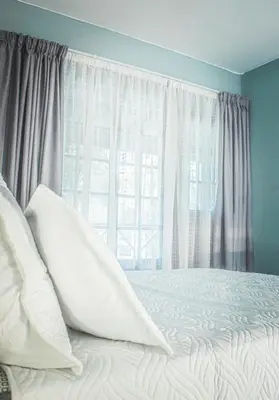 a bedroom with a bed with white pillows and a window at 19 @ Pendleberry in Bela-Bela