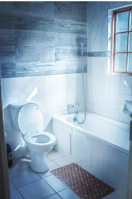 a bathroom with a toilet and a tub and a sink at 19 @ Pendleberry in Bela-Bela