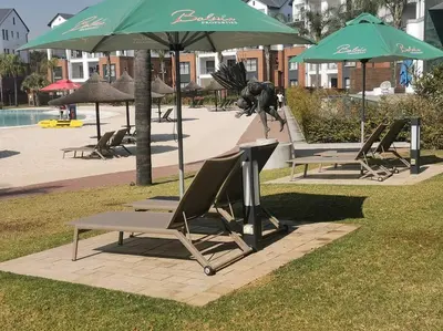 a group of chairs and umbrellas next to a pool at The Blyde Luxury Retreat in Pretoria