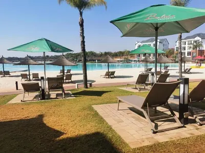 a group of chairs and umbrellas next to a beach at The Blyde Luxury Retreat in Pretoria