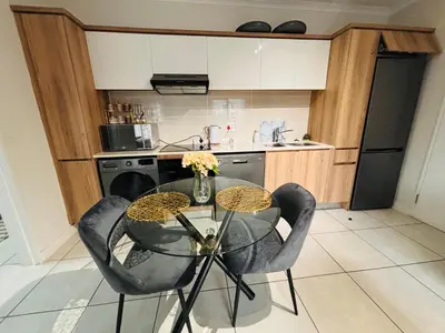 a kitchen with a glass table and two chairs at The Blyde Luxury Retreat in Pretoria