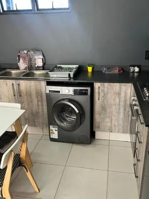 a washing machine in a kitchen next to a sink at Lakhe Lethu Apartment: Green Valley Estate in Nelspruit