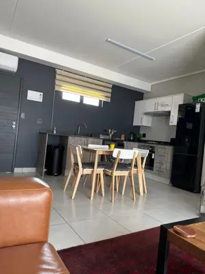 a kitchen and dining room with a table and chairs at Lakhe Lethu Apartment: Green Valley Estate in Nelspruit