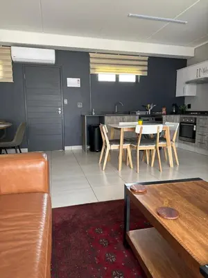 a kitchen and living room with a table and chairs at Lakhe Lethu Apartment: Green Valley Estate in Nelspruit