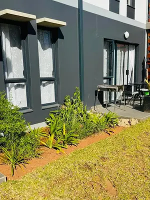 a building with a patio with a table and chairs at Lakhe Lethu Apartment: Green Valley Estate in Nelspruit