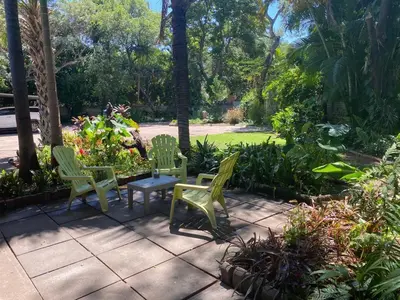 two green chairs and a table on a patio at Four Seasons Guesthouse - Hardekool 7 in Lephalale