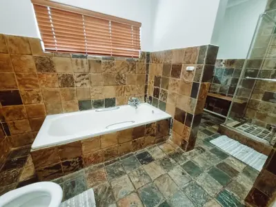 a bathroom with a tub and a shower at Four Seasons Guesthouse - Hardekool 7 in Lephalale