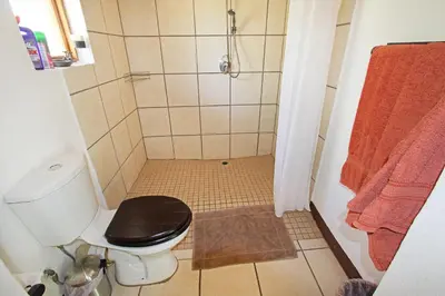 a small bathroom with a toilet and a shower at Normann Safari Bush Lodge in Phalaborwa