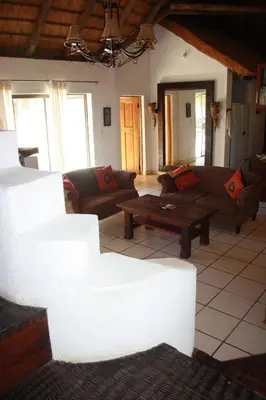 a living room with couches and a coffee table at Normann Safari Bush Lodge in Phalaborwa