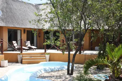a resort with a swimming pool in front of a building at Normann Safari Bush Lodge in Phalaborwa