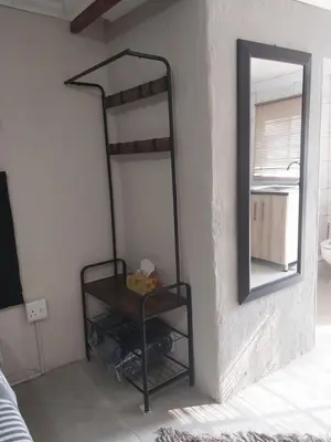 a black shelf in a room with a mirror at Comfort place 3 in Pretoria