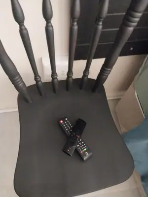 two remote controls sitting on top of a chair at Comfort place 3 in Pretoria