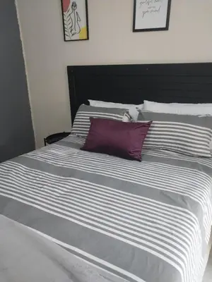 a large white bed with a purple pillow on it at Comfort place 3 in Pretoria
