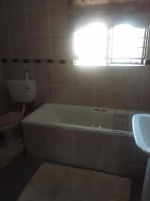 a bathroom with a tub and a toilet and a sink at Room2rent Centurion in Pretoria