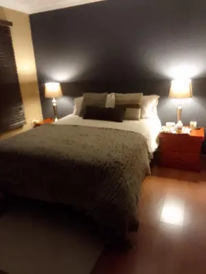 a bedroom with a large bed and two lamps at Room2rent Centurion in Pretoria