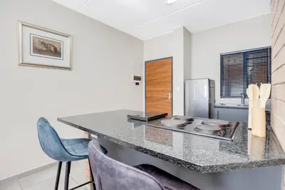 a kitchen with a counter top and a refrigerator at The Sunrise Waterfall in Midrand