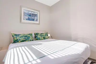 a bedroom with a large white bed with pillows at The Sunrise Waterfall in Midrand