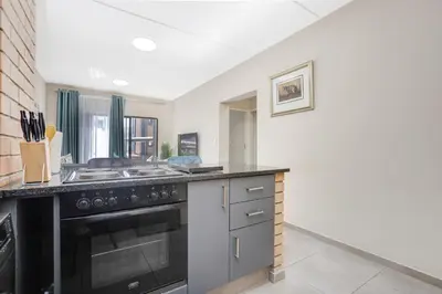 a kitchen with a stove and a sink at The Sunrise Waterfall in Midrand