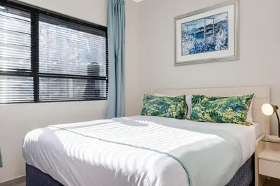 a bedroom with a large bed and a window at The Sunrise Waterfall in Midrand