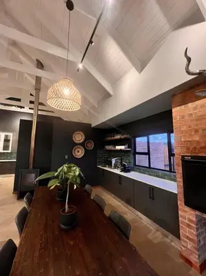 a dining room with a wooden table with a plant at Highland Gate Range View in Dullstroom