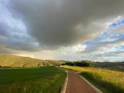 a dirt road in the middle of a green field at Highland Gate Range View in Dullstroom