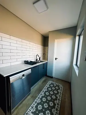 a kitchen with blue cabinets and a sink and a rug at Highland Gate Range View in Dullstroom