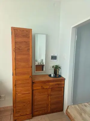 a bathroom with a wooden dresser with a mirror at Sunny Stay in Groblersdal