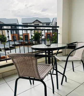 a table and chairs on a balcony with a view at The Blyde in Pretoria