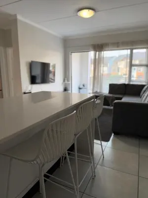 a kitchen and living room with a table and chairs at The Blyde in Pretoria