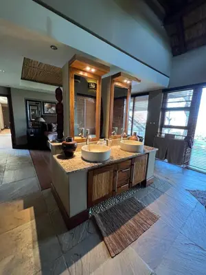 a bathroom with two sinks in a room at Pumula Bush Main House in Mabula