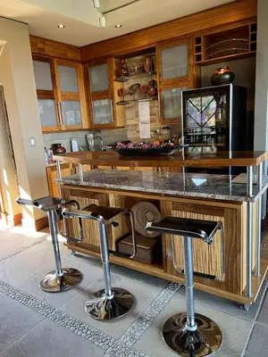 a kitchen with a counter with two bar stools at Pumula Bush Main House in Mabula