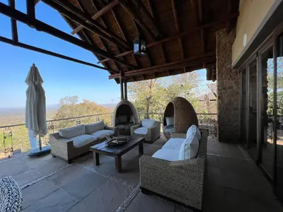 an outdoor patio with couches and a table at Pumula Bush Main House in Mabula