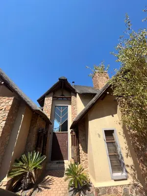 a house with a brown door and some plants at Pumula Bush Main House in Mabula