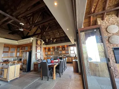 a kitchen and dining room with a table and chairs at Pumula Bush Main House in Mabula