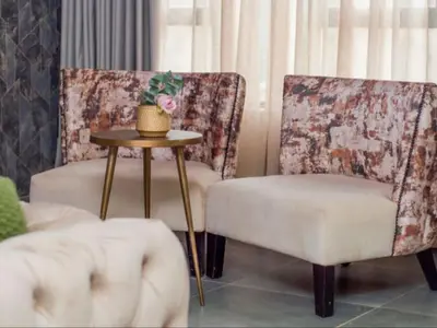 a living room with two chairs and a table at The Lux Hotel and Resorts in Louis Trichardt